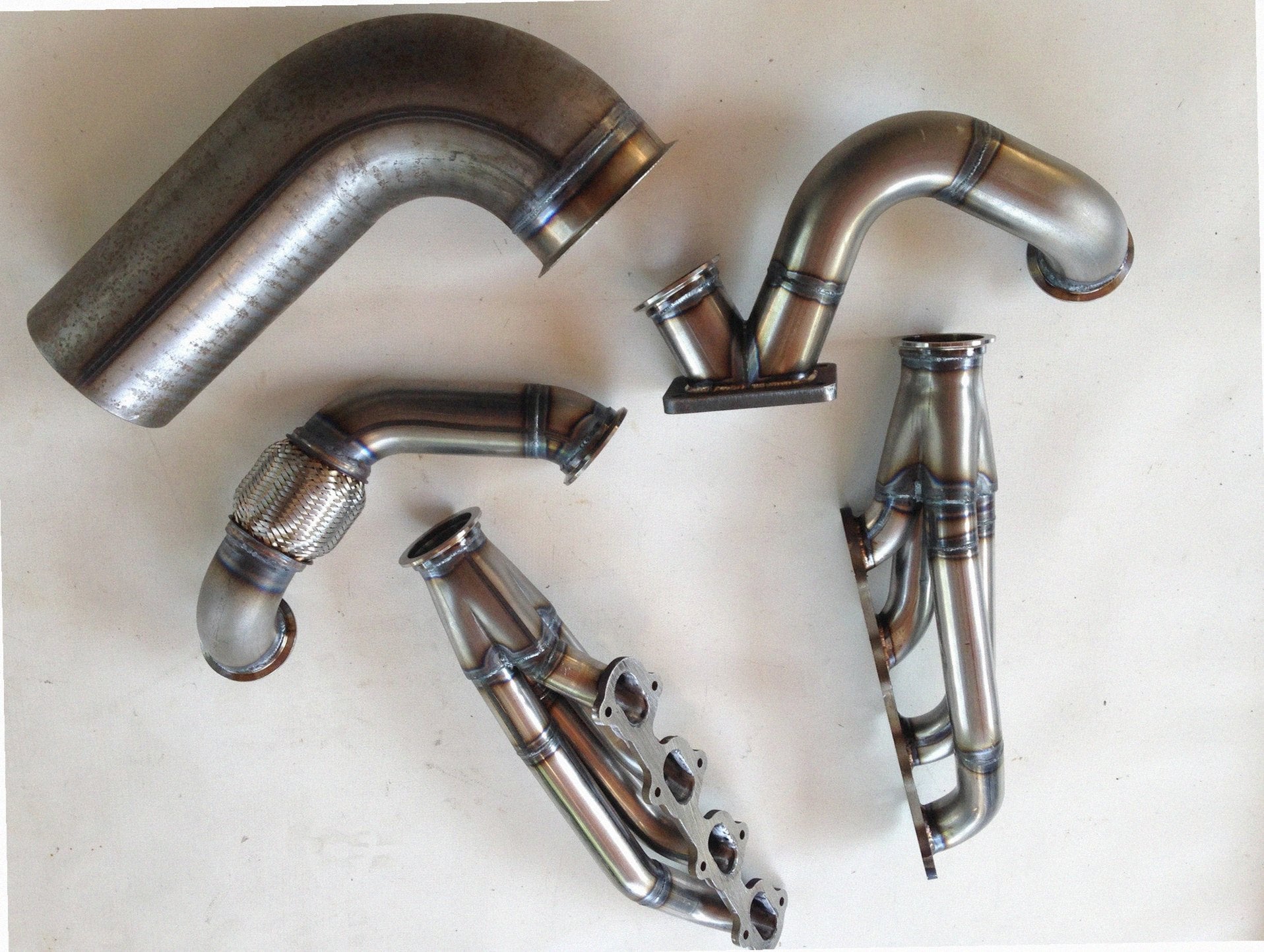 Modular 4V TO6 Turbo Race Kit — complete turbo hot-side kit with mild steel tubular headers, crossover pipe with flex bellow, starter downpipe, and turbo mount flange