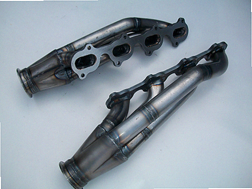 5.4 2V Racing Headers — facing-forward tubular turbo headers in mild steel with V-band flanges and CNC head flanges